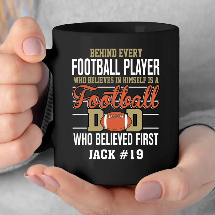 Personalized Behind Every Football Player Who Believes In Himself Is A Football Dad Who Believe First Mug, Custom Mug For Football Dad, Football Mom